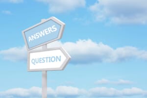 A signpost with 'ANSWERS' and 'QUESTION' arrows against a blue sky.