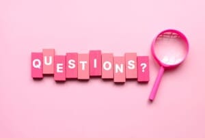 A pink magnifying glass over a document, symbolizing a Q&A or inquiry concept.