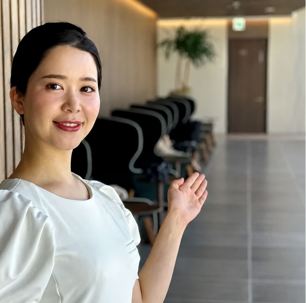 A welcoming medical staff smiling and gesturing in the refined clinic interior, embodying BIANCA CLINIC's exceptional hospitality.